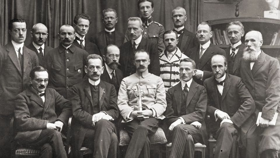 Rząd Jędrzeja Moraczewskiego 18 listopada 1918. W pierwszym rzędzie siedzą (od lewej): Stanisław Thugutt, Jędrzej Moraczewski, Józef Piłsudski, Leon Supiński, Leon Wasilewski. źrodło: https://pl.wikipedia.org/wiki/J%C3%B3zef_Pi%C5%82sudski