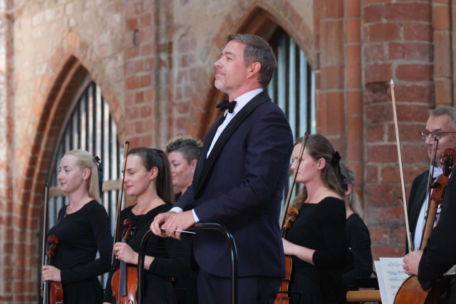 Przemysław Neumann – dyrygent przyjmuje z Orkiestrą Symfoniczną Filharmonii w Szczecinie gorące brawa publiczności Choriner Musicsommer w Niemczech. Fot. Dariusz Gorajski Szczecińscy filharmonicy w Chorin. To preludium do obchodów 150. rocznicy urodzin Karłowicza [ROZMOWA, ZDJĘCIA]