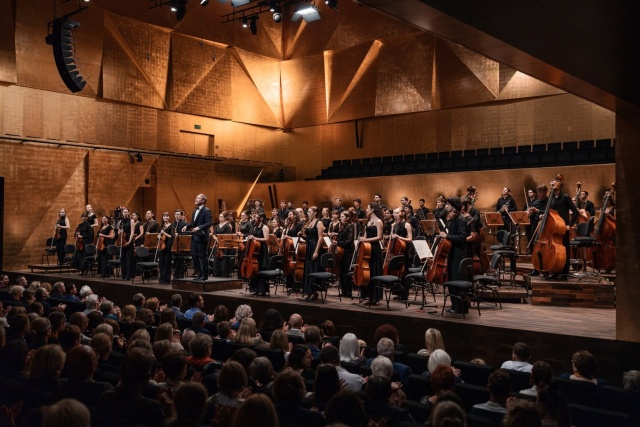 Maestro Przemysław Neumann przyjmuje owacyjne brawa publiczności z Internatiol Lutosławski Youth Orchestra. Fot. Piotr Nykowski Finał 14. edycji ILYO w Szczecinie i Katowicach muzycznym wulkanem energii [POSŁUCHAJ, ZDJĘCIA]
