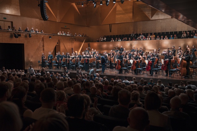Przemysław Neumann – dyrygent przyjmuje owacyjne brawa publiczności z International Lutosławski Youth Orchestra 2025 w Złotej Sali Filharmonii im. Mieczysława Karłowicza w Szczecinie. Fot. Piotr Nykowski Wirtuozowski finał projektu ILYO 2025 w Filharmonii w Szczecinie i lipskim Gewandhausie [POSŁUCHAJ, ZDJĘCIA]