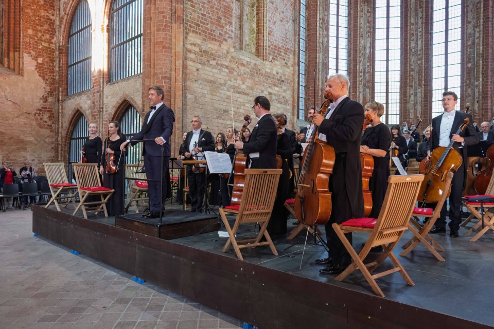 Przemysław Neumann – dyrygent przyjmuje z Orkiestrą Symfoniczną Filharmonii w Szczecinie gorące brawa publiczności festiwalu Choriner Musicsommer w Niemczech. Fot. Dariusz Gorajski