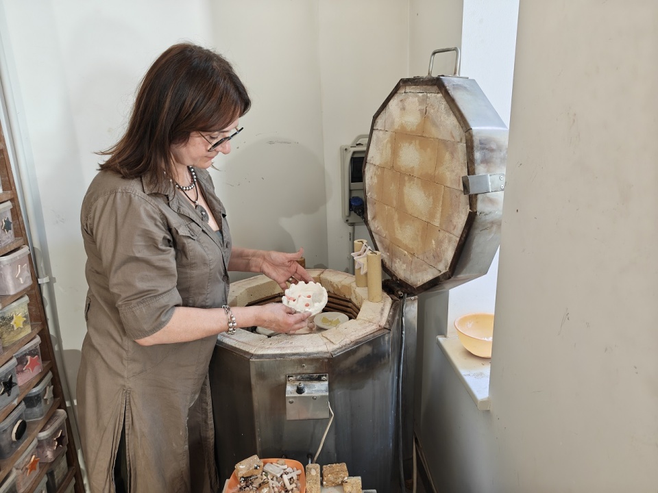 Pani Jola wyjmuje z pieca wyroby ceramiczne