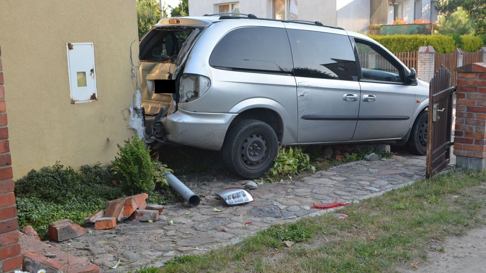 Pijany kierowca Chryslera cofając staranował bramę wjazdową oraz część ogrodzenia i zatrzymał się na ścianie. Fot. Mat. Policji