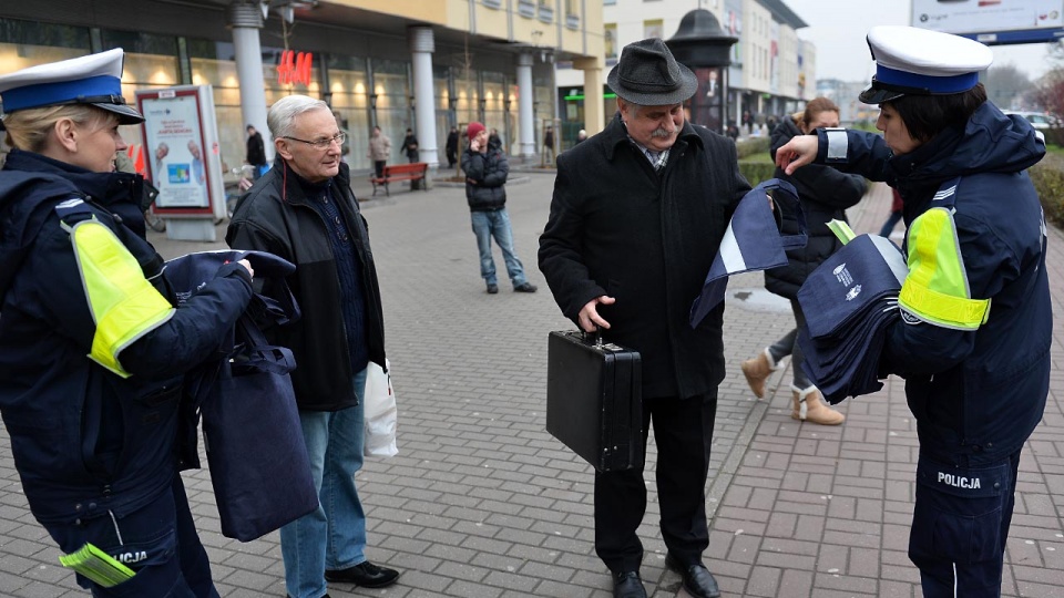 Policjanci z komendy miejskiej w Szczecinie w pół godziny rozdali w środę przed Centrum Handlowym Turzyn ponad 200 opasek i ponad 100 toreb z elementem odblaskowym. Fot. Łukasz Szełemej [Radio Szczecin]