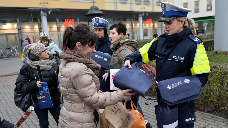 Policjanci z komendy miejskiej w Szczecinie w pół godziny rozdali w środę przed Centrum Handlowym Turzyn ponad 200 opasek i ponad 100 toreb z elementem odblaskowym. Fot. Łukasz Szełemej [Radio Szczecin]