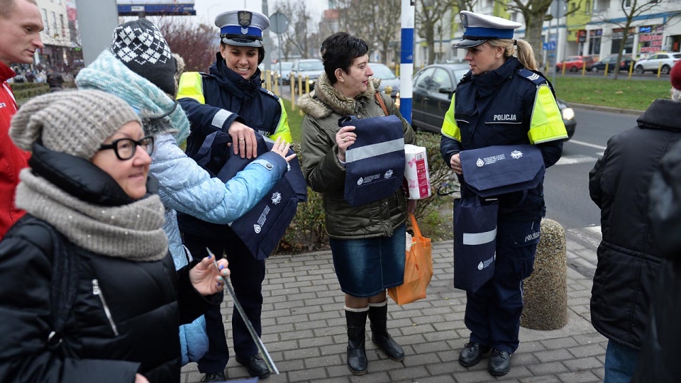 Policjanci z komendy miejskiej w Szczecinie w pół godziny rozdali w środę przed Centrum Handlowym Turzyn ponad 200 opasek i ponad 100 toreb z elementem odblaskowym. Fot. Łukasz Szełemej [Radio Szczecin]