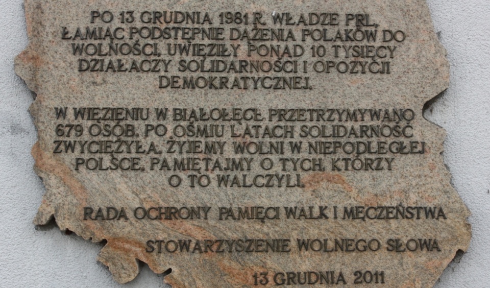 Tablica na murze Aresztu Śledczego Warszawa-Białołęka upamiętniająca internowanych. Fot. Wikimedia Commons/Grzegorz Gołębiowski