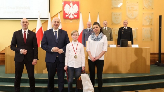 Szef MSWiA Joachim Brudziński w Opolu wręczył medale Młodych Bohaterów dwóm nieletnim, którzy wykazali się bohaterskimi czynami. Otrzymali je mieszkańcy województwa opolskiego: Karolina Łada i Denis Korzeniowski.