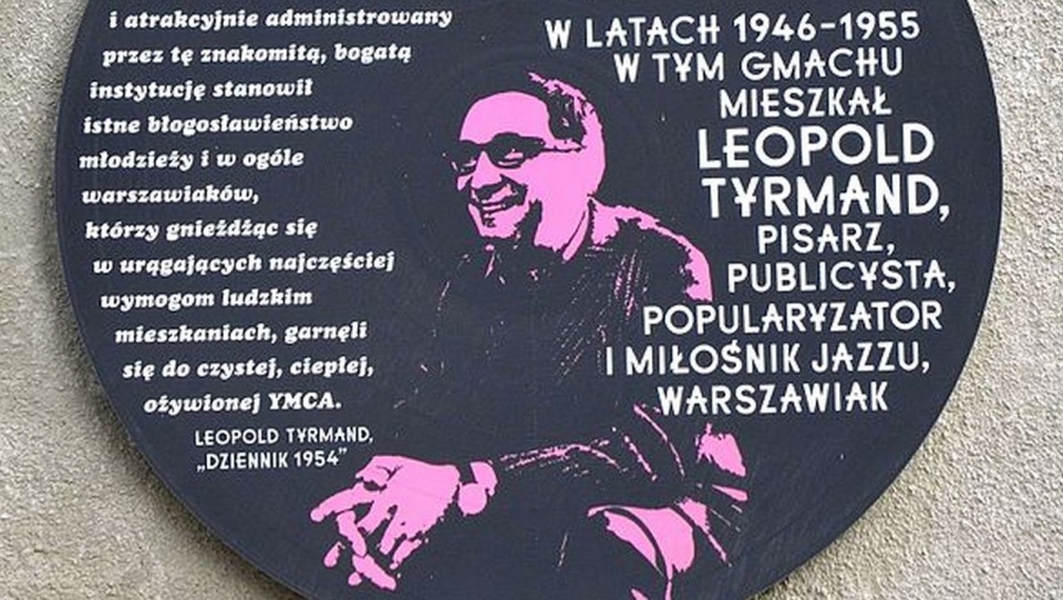 Tablica pamiątkowa. źródło: https://pl.wikipedia.org/wiki/Leopold_Tyrmand