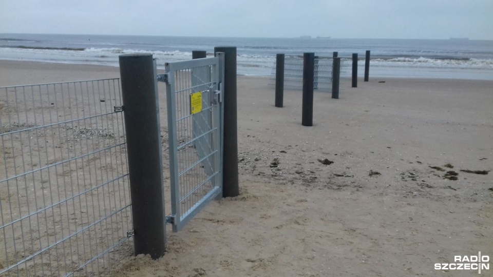 Na płocie znajdują się informacje w języku polskim z prośbą o zamykanie drzwi i informacją, że konstrukcja ma zabezpieczać przed migracją dzików. Fot. Joanna Maraszek [Radio Szczecin]