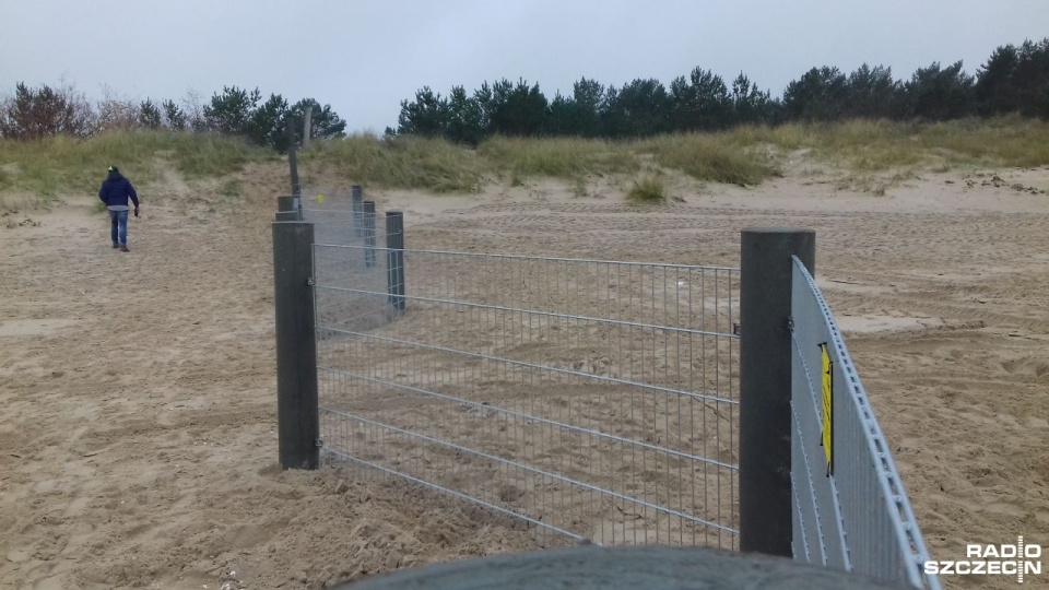 Na płocie znajdują się informacje w języku polskim z prośbą o zamykanie drzwi i informacją, że konstrukcja ma zabezpieczać przed migracją dzików. Fot. Joanna Maraszek [Radio Szczecin]