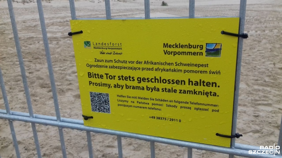 Na płocie znajdują się informacje w języku polskim z prośbą o zamykanie drzwi i informacją, że konstrukcja ma zabezpieczać przed migracją dzików. Fot. Joanna Maraszek [Radio Szczecin]