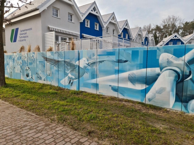 Śmigło turbiny wiatrowej, mewa, dmuchawiec, łańcuch DNA, chmury i wiatr - a wszystko w bieli i błękicie. Taki mural zdobi mur ośrodka wypoczynkowego ZUT w Dziwnowie.