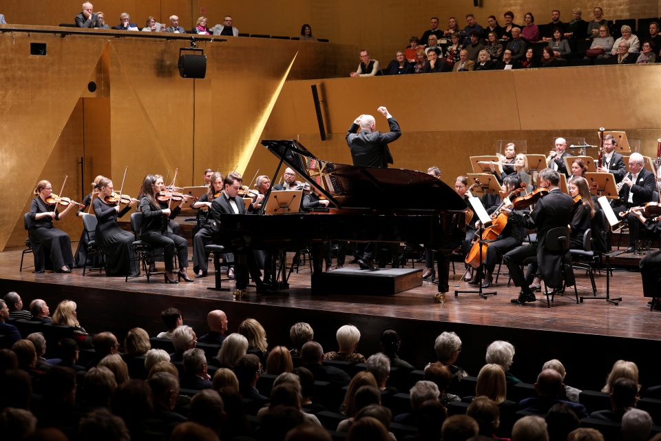 Mateusz Krzyżowski – pianista gra z Orkiestrą Filharmonii im. Mieczysława Karłowicza w Szczecinie pod batutą Michała Klauzy. Fot. Cezary Aszkiełowicz