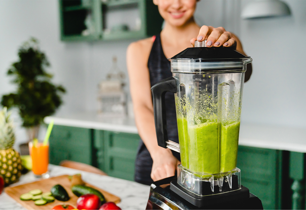 Kobieta przygotowująca smoothie z warzyw i owoców Kobieta przygotowująca smoothie z warzyw i owoców
