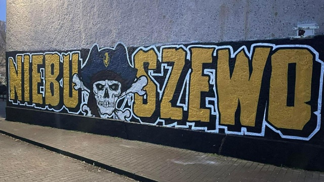 Burza wokół muralu, który powstał na ścianie jednego z budynków Szkoły Podstawowej nr 69 w Szczecinie. Jest na nim duży napis Niebuszewo, w środku trupia czaszka z kośćmi i piracki kapelusz z logo Pogoni Szczecin.