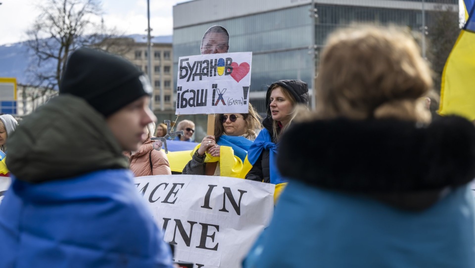 Ukrainian protesters hold placards as they demonstrate in front of the European headquarters of the United Nations in Geneva, Switzerland, 17 February 2026. The United States, Ukraine, and Russia are meeting in Geneva to discuss a peace plan aimed at ending the war. EPA/MARTIAL TREZZINI